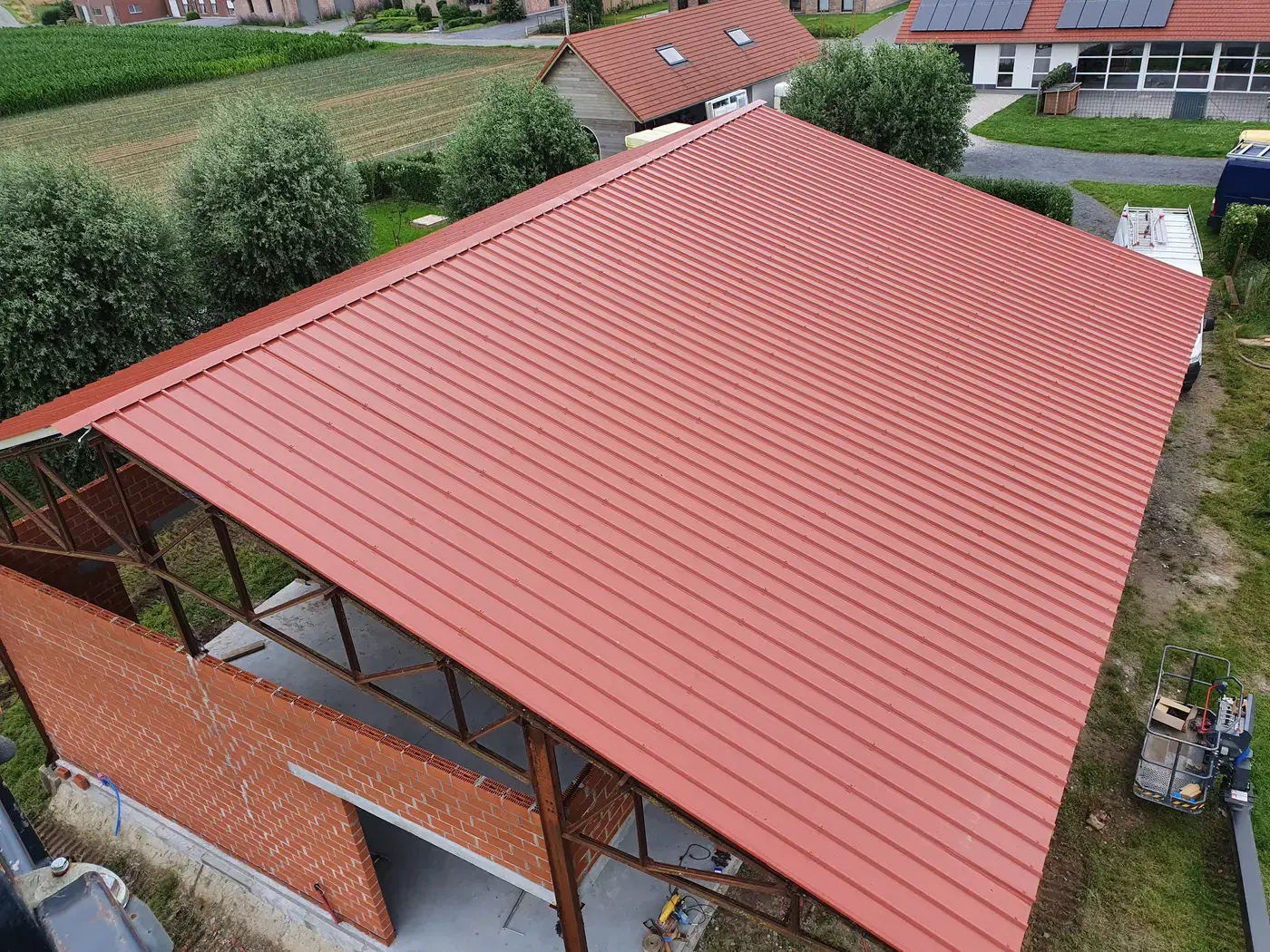 Luchtfoto van een afgewerkt stalen dak op een loods met zichtbare staalstructuur