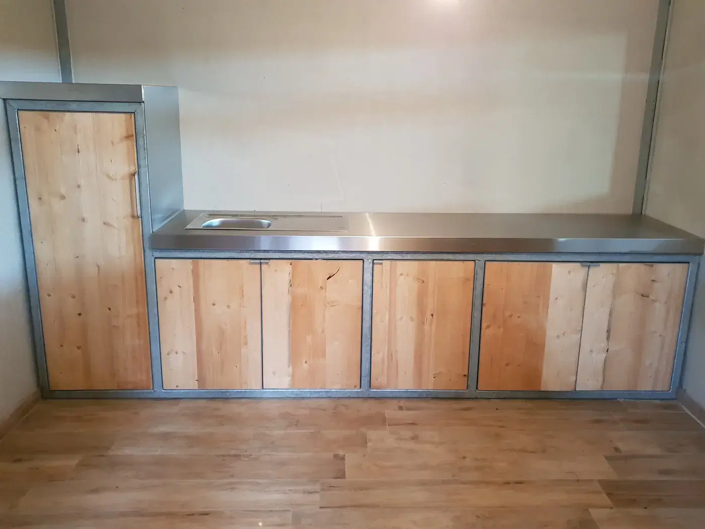 Maatwerk keukenmeubel met stalen frame, houten deuren en inox werkblad