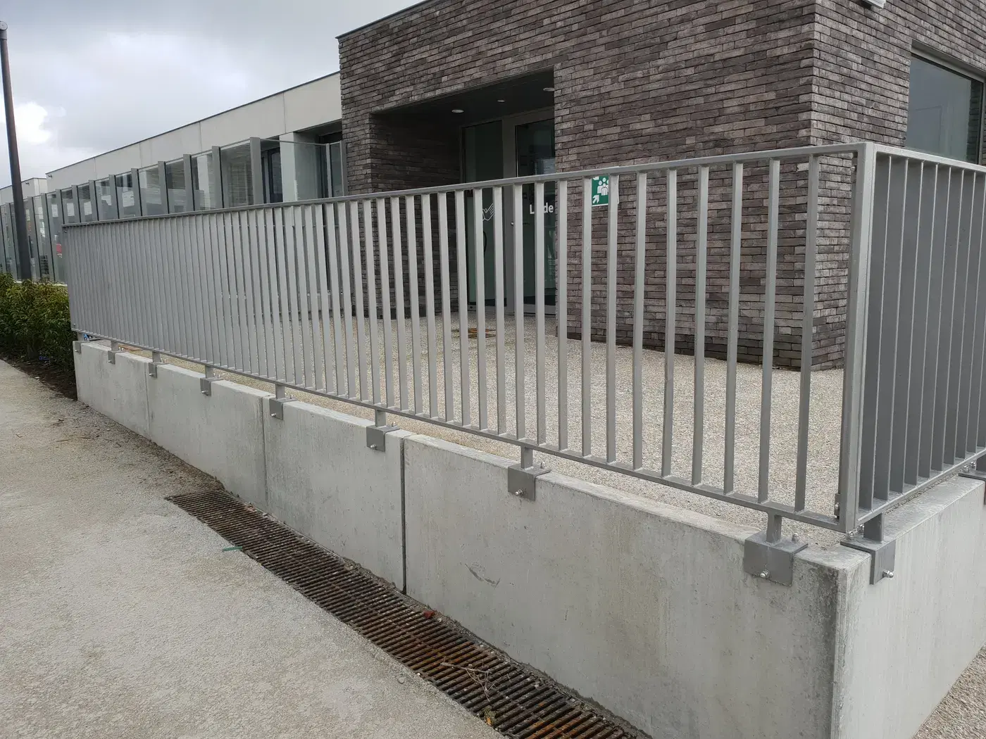 Grijs gelakte spijlenbalustrade op betonnen keerwanden