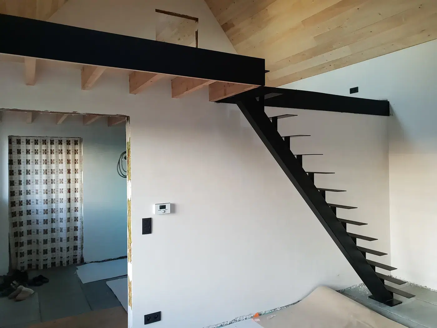 Zwarte zwevende designtrap op middenboom naar een mezzanine